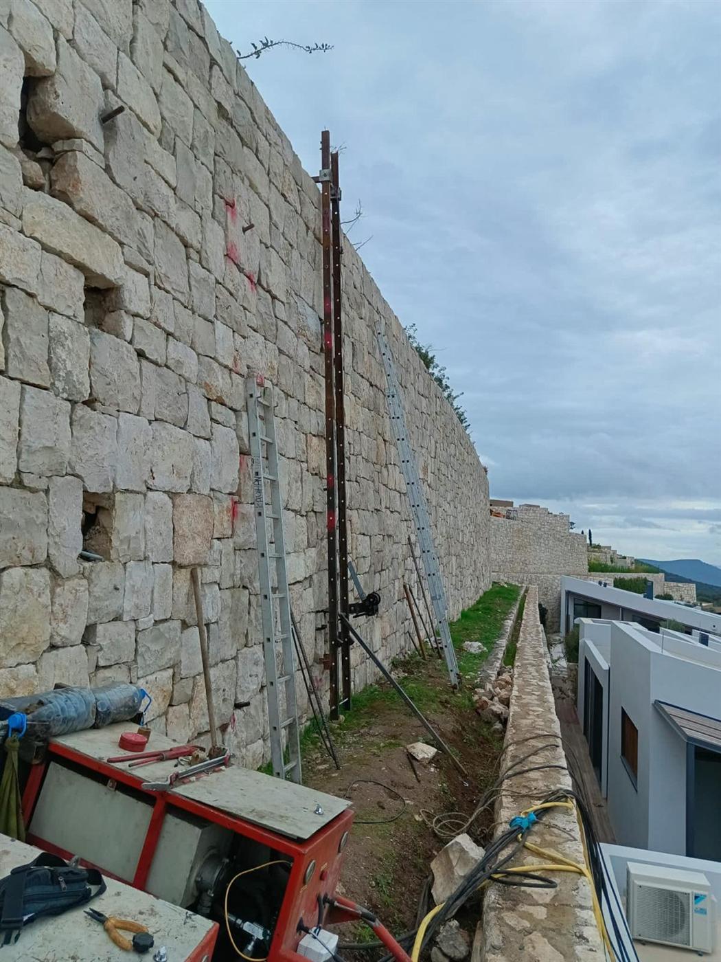 Drilling works in a narrow corridor beside residential buildings