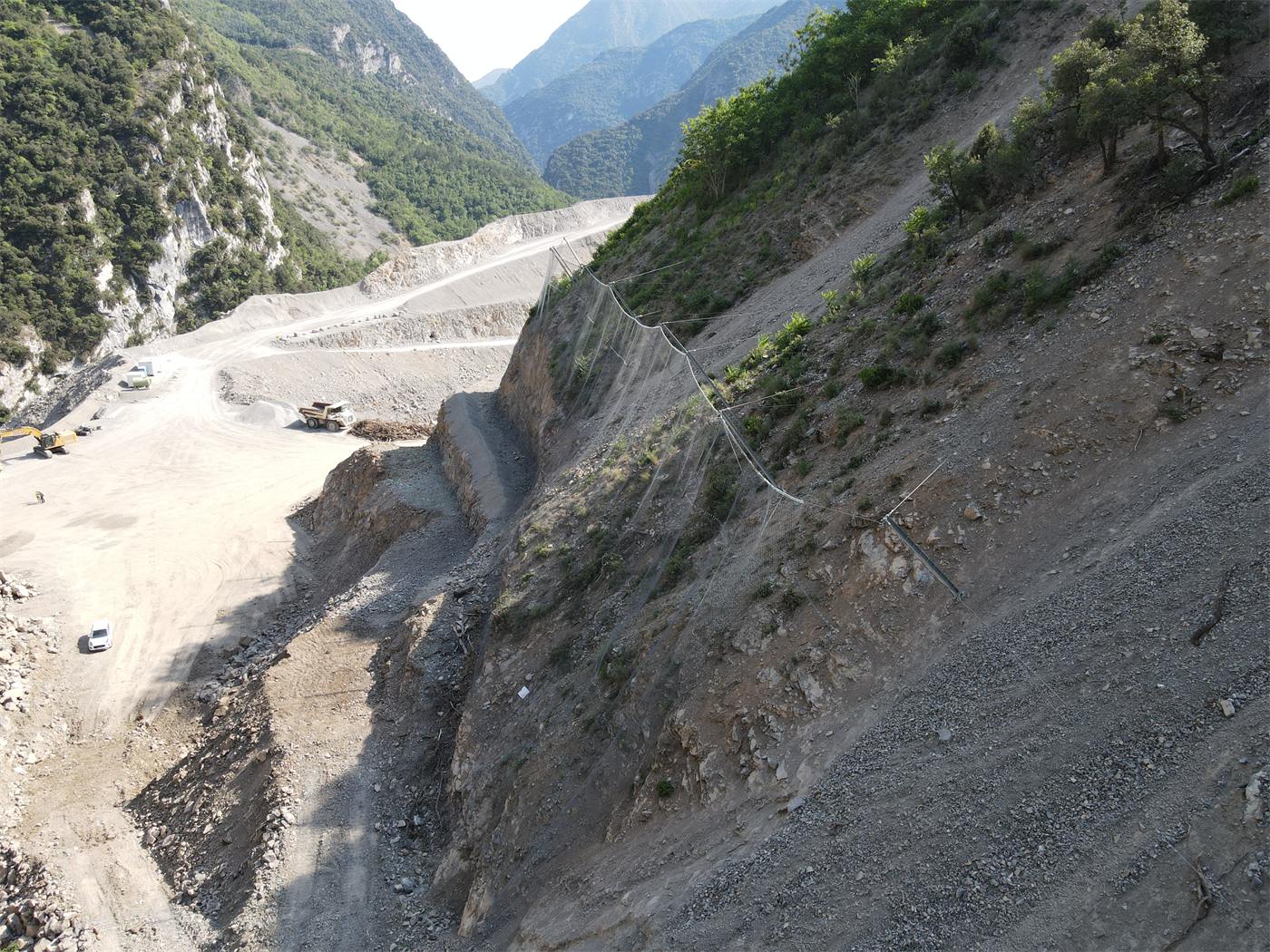 Rockfall barrier lines above a wadi corridor