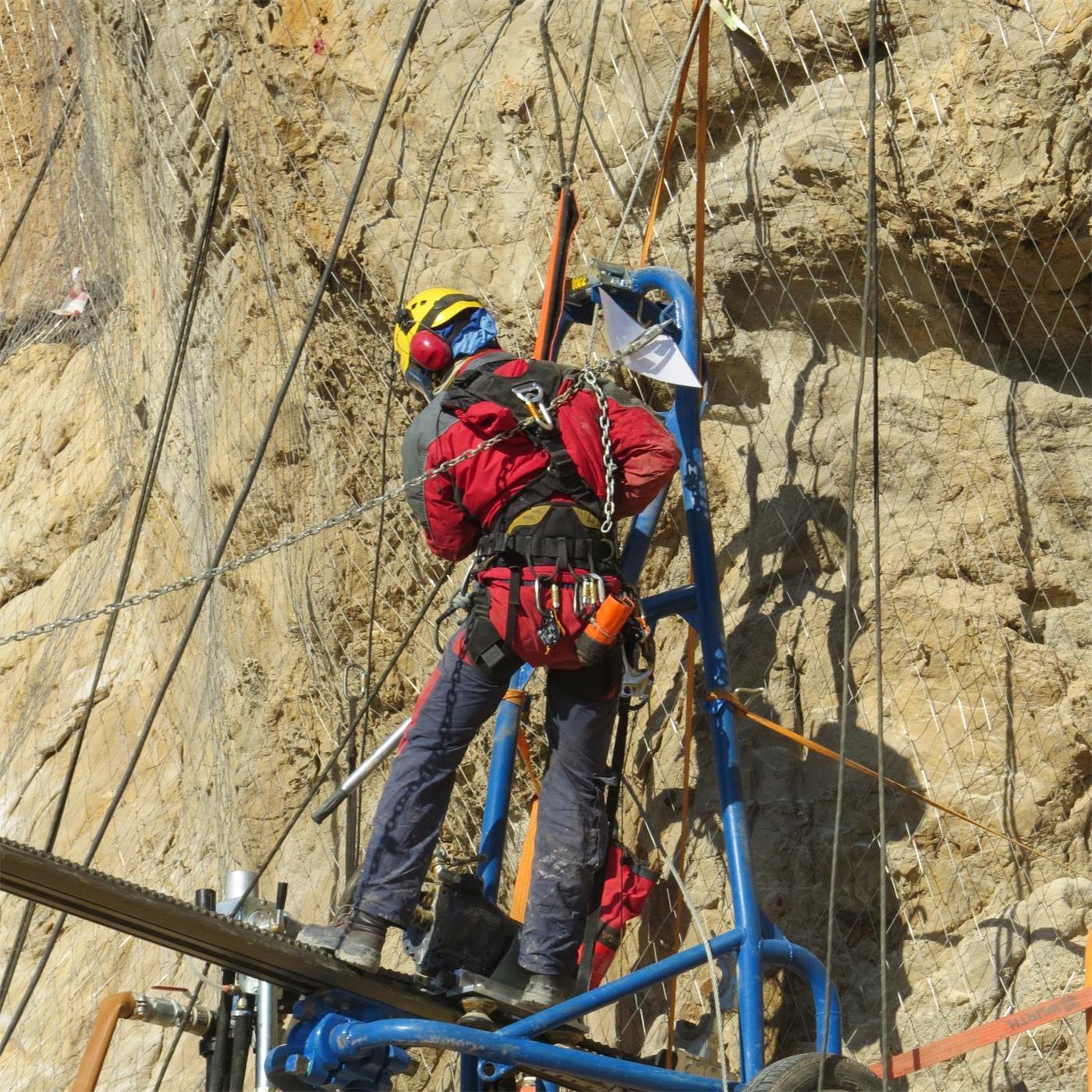 Rope access drilling team on a vertical wall