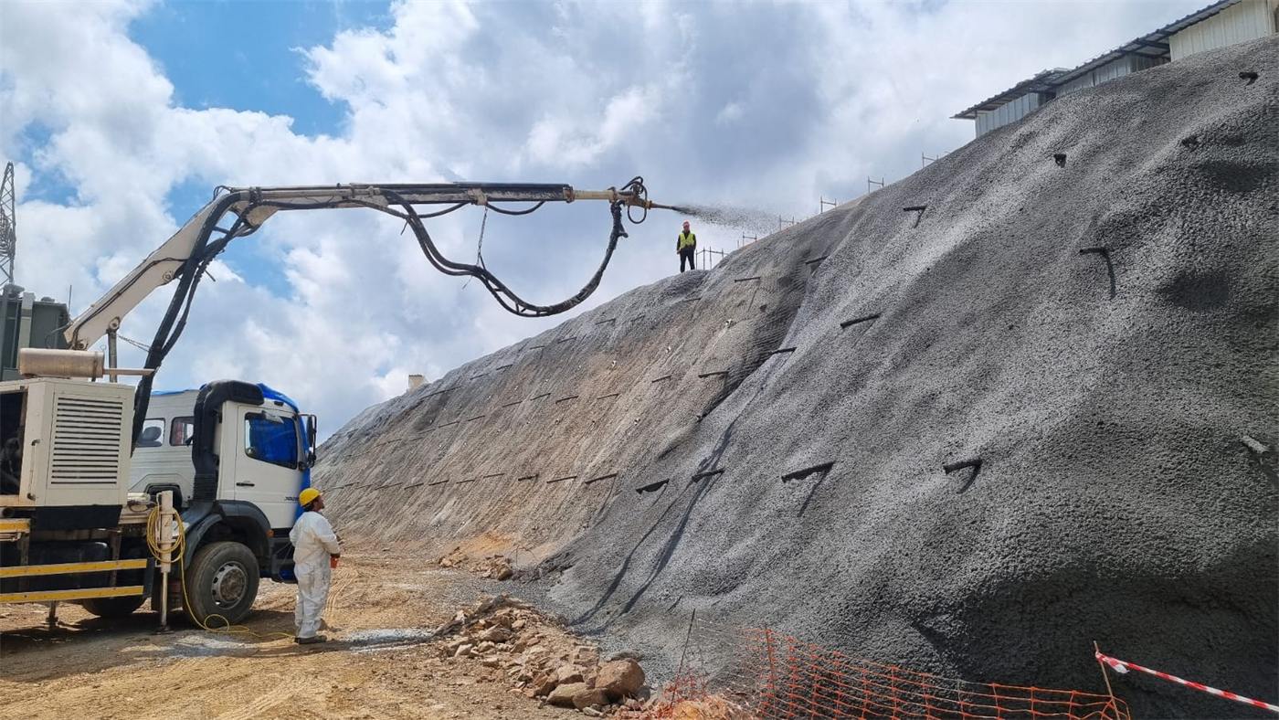 Robotic boom spraying concrete on a large slope