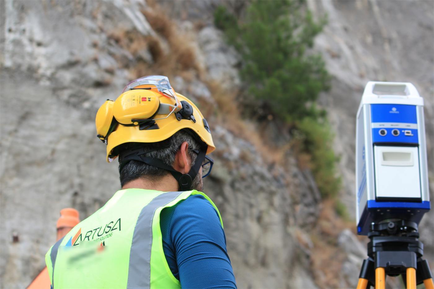 Engineer operating a terrestrial laser scanner at a rock slope