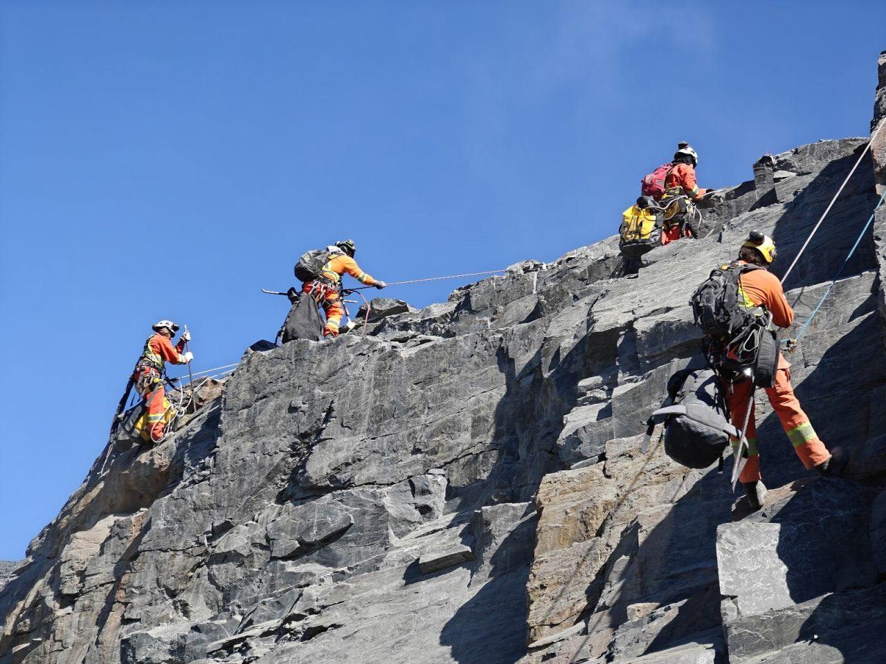 Scaling crew working on a rocky crest