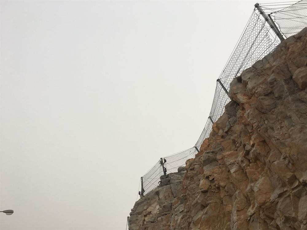 Clifftop rockfall fence above the sea in Oman