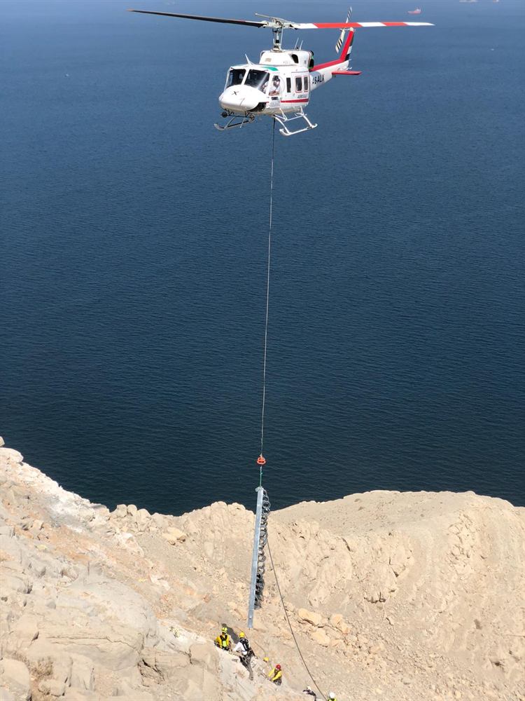 Helicopter lifting material to a cliff